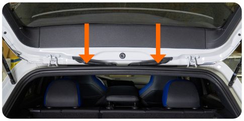 Two arrows pointing down at the headliner clip locations above the rear seats of a VW Golf