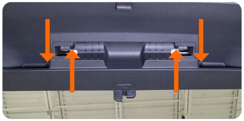 Four arrows pointing to the T25 screw locations on the hatch trim panel of a VW Golf
